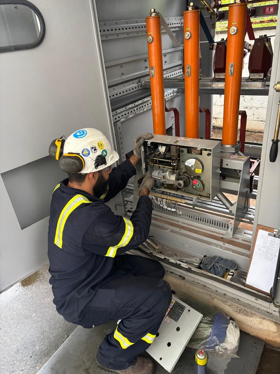 Profissional realizando manutenção em cabine de média tensão