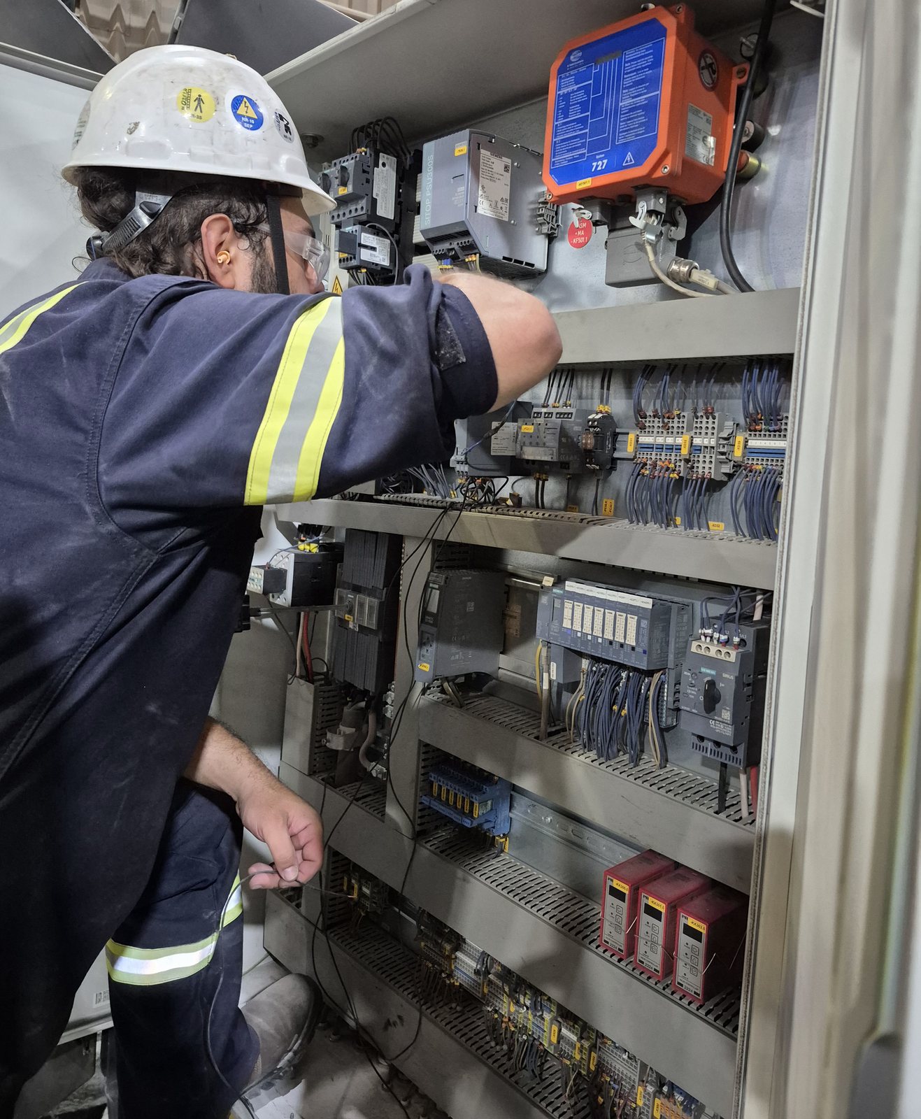 Profissional realizando ligação em painel elétrico